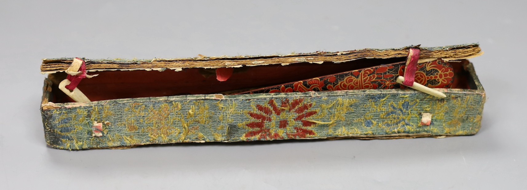 A Chinese gilt-decorated lacquer fan in a brocade covered case, 19th century